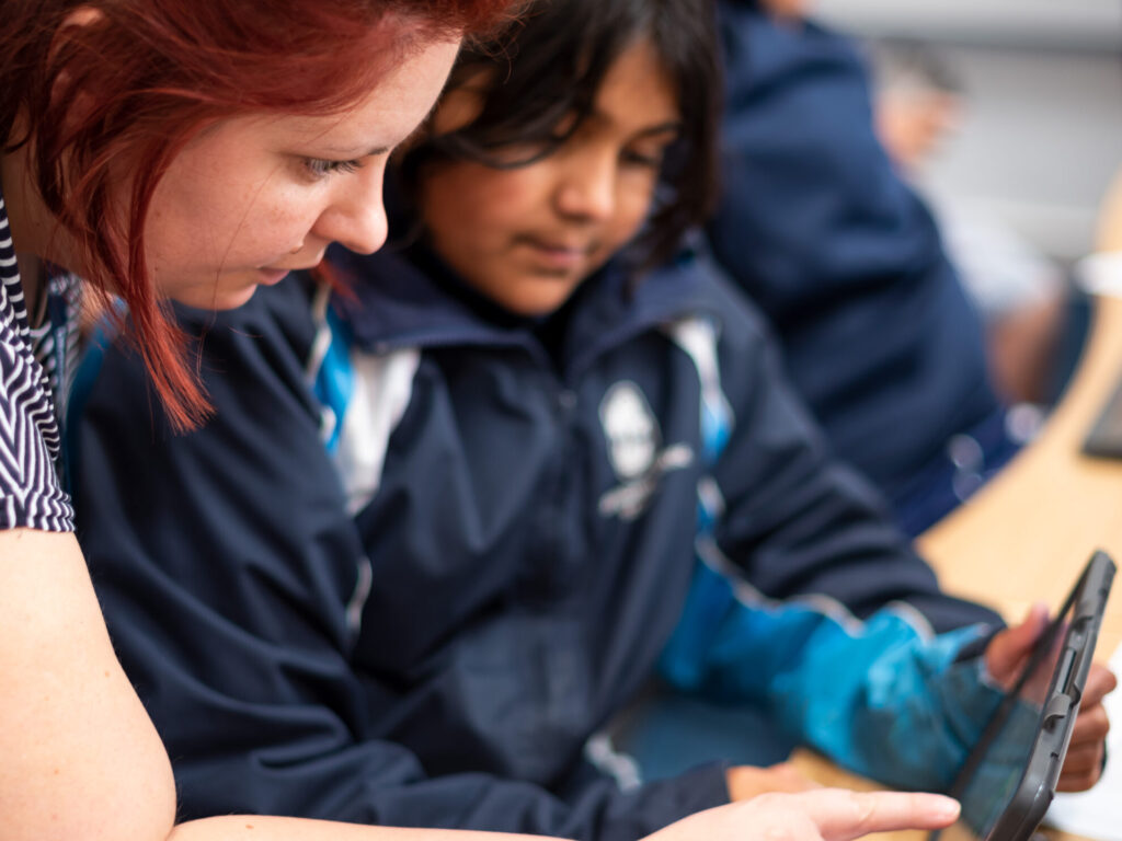 Head of Technology teaching a Devonshire House student on a tablet.