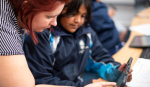 Head of Technology teaching a Devonshire House student on a tablet.